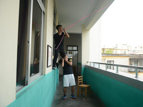 男生在帮忙挂晾衣绳