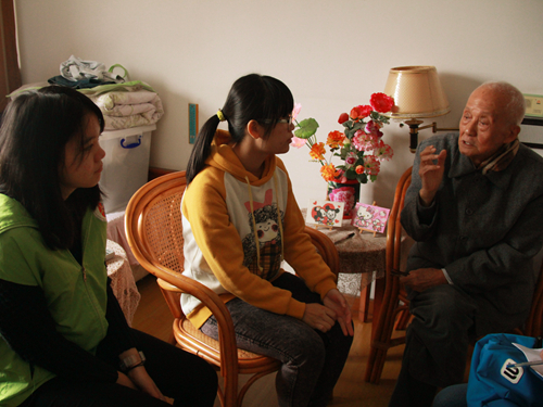 志愿者认真听郭爷爷讲自己的经历