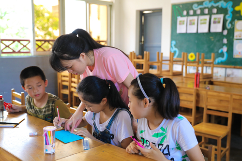 手工课上老师辅导制作猫头鹰面具