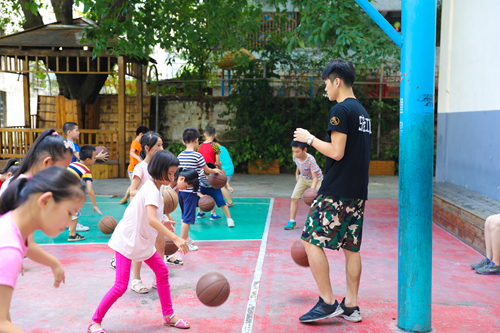 体育老师教导学生运球
